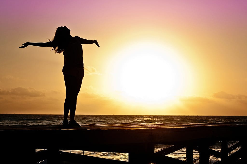 Silhouette of person on pier at sunset
