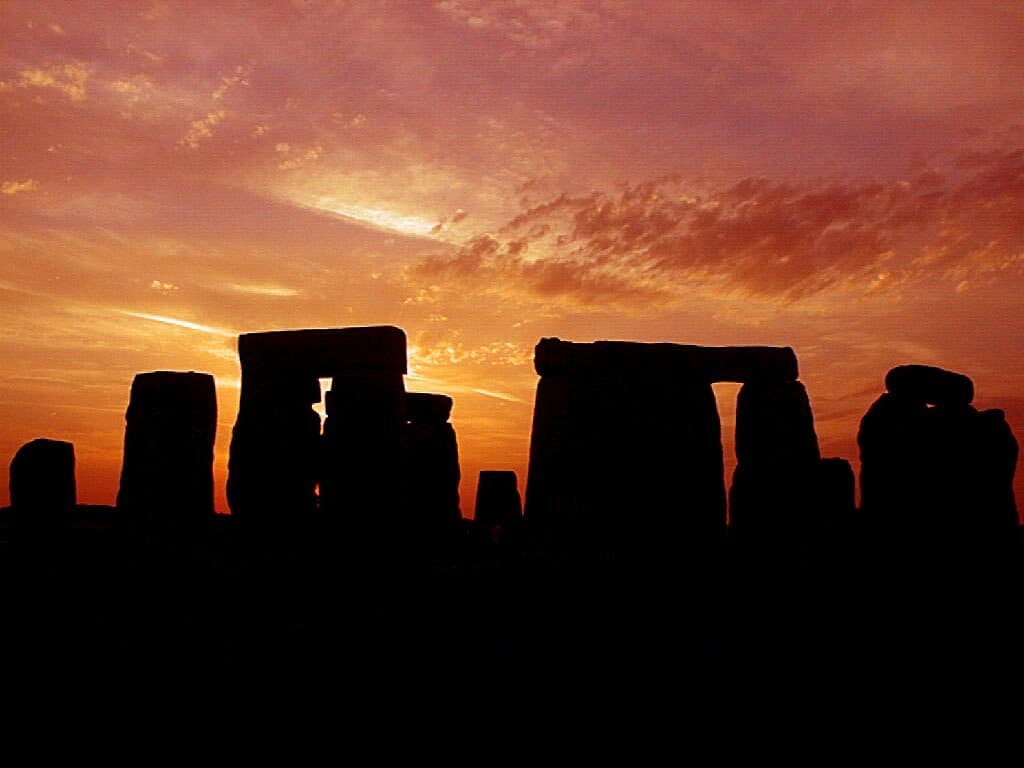 Stonehenge silhouette against orange sunset sky