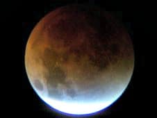 Partial lunar eclipse showing red moon and glow