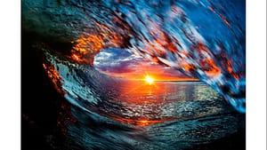 Sunset through curling ocean wave barrel