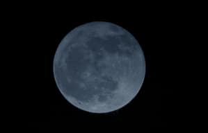 Blue-tinted full moon against black sky