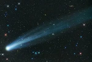 Bright comet with long icy tail across stars