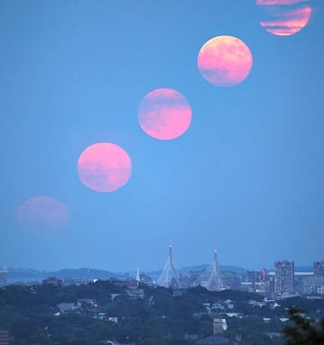 Multiple pink moons rising over city skyline