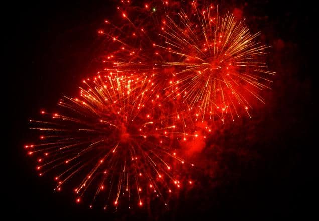 Red fireworks bursting against dark night sky
