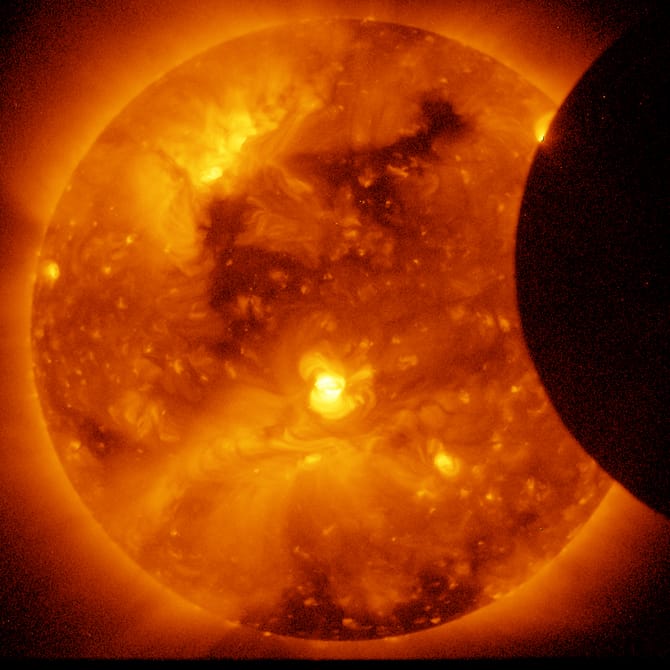Partial solar eclipse with dark circular silhouette