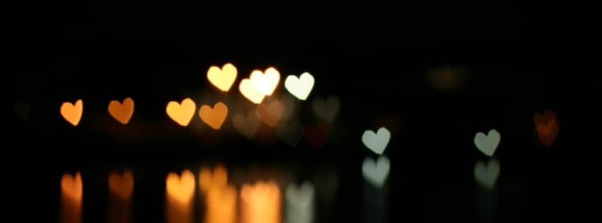 Heart-shaped bokeh lights reflected on water
